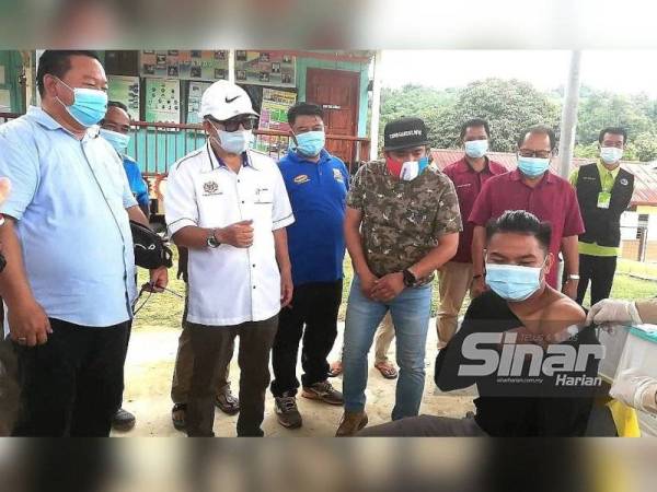 Maximus beri penerangan dalam bahasa Dusun kepada salah seorang penduduk yang menerima vaksin Covid-19 di Kampung Sungai Magandai, Kota Marudu.