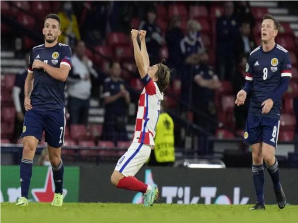 Pemain Scotland kelihatan murung manakala pemain Croatia, Luka Modric, menjerit gembira apabila pengadil meniup wisel penamat bagi aksi kedua-dua pasukan, pada awal pagi Rabu. - Foto EPA