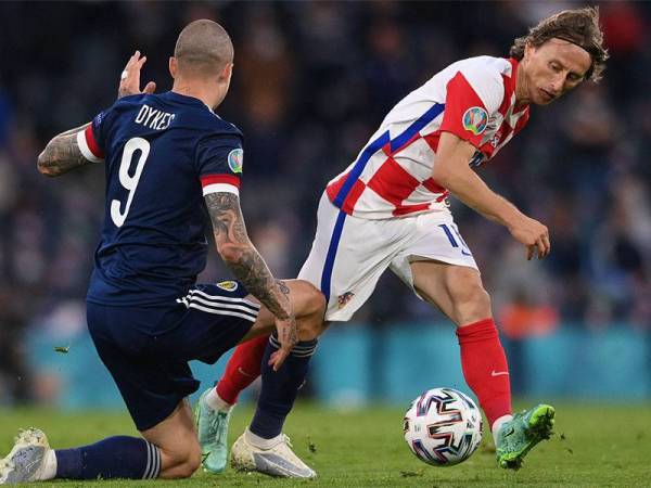 Modric (kanan) dikawal ketat pemain Scotland, Lyndon Dykes semasa aksi Kumpulan D saingan Euro 2020 di Stadium Hampden Park, Glasgow. FOTO: AFP