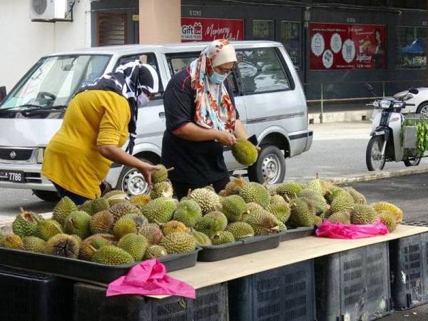 Beberapa pembeli sedang memilih durian yang dijual Azizon.