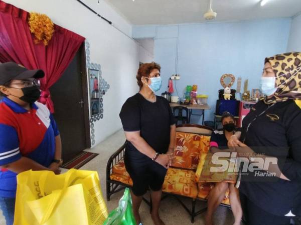 Suganthi ketika menerima kunjungan Nor Raidah (kiri) dan Puteri Holijah (kanan) yang hadir menyampaikan sumbangan.