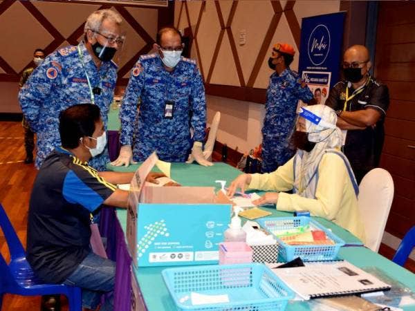 Mohd Redzuan (kiri) melakukan lawatan ke Pusat Pemberian Vaksin (PPV) di Pusat Kecemerlangan, Kejuruteraan dan Teknologi, pada Khamis. - Foto Bernama
