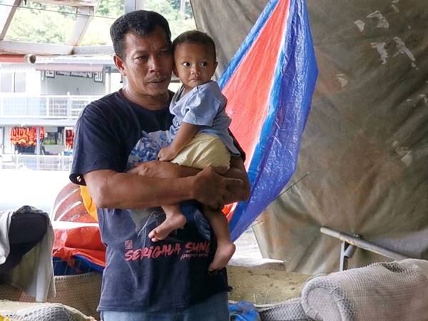 Samsuddin mendukung bayinya, Nor Farhan Iskandar yang kini berusia 8 bulan.