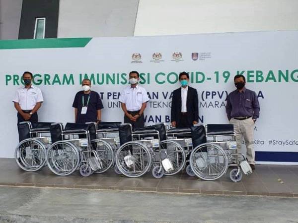 Saipolyazan (tiga dari kanan) menyerahkan kerusi roda kepada Hospital UiTM di Dewan Berlian, UiTM Puncak Alam pada Jumaat.