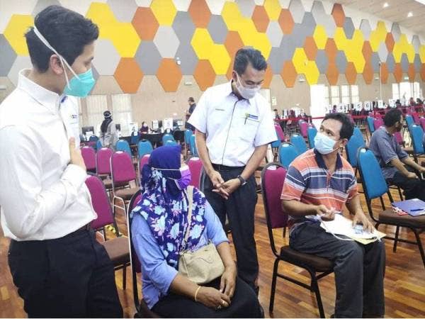 Saipolyazan (tiga dari kiri) diiringi Pengarah Hospital UiTM, Profesor Dr Sazzli Shahlan Kasim (kiri) menyantuni penerima vaksin di Dewan Berlian UiTM Puncak Alam, Kuala Selangor pada Jumaat.