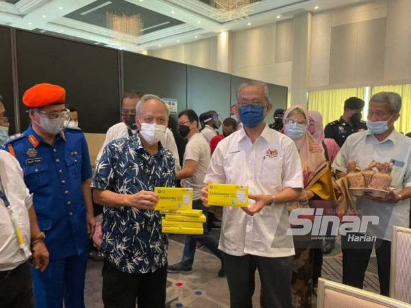 Datuk Kamarudin (depan, dari kanan), Datuk Nasir (depan,tengah) menyerahkan pelitup muka kepada petugas PPV