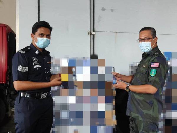 Rizal (kanan) melihat antara minuman keras tidak bercukai yang dirampas dalam serbuan Op Kontraban di sebuah premis stor di Kawasan Perindustrian Hi Tech 3 Semenyih pada Jumaat.