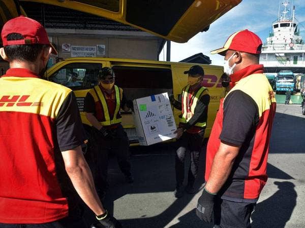Petugas-petugas DHL Express membawa sebanyak 3,020 dos bekalan vaksin Pfizer-BioNTech yang tiba di Terminal Feri Antarabangsa Labuan ketika tinjauan hari ini.