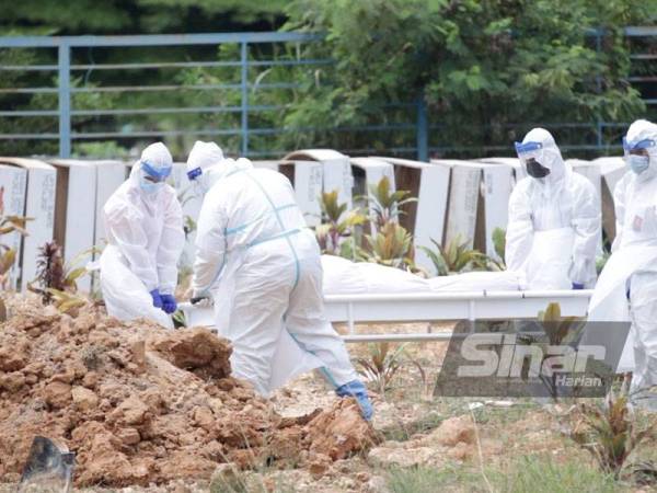 Frontliners membantu menyempurnakan pengembumian jenazah mangsa Covid-19.