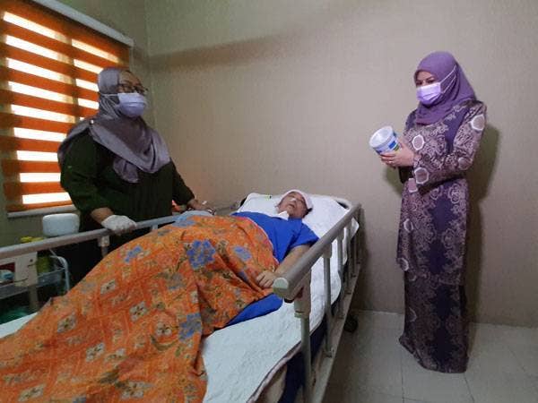 Rina (kanan) melawat Jahidah yang terlantar di rumah adiknya di Bandar Sri Sendayan, Seremban pada Sabtu.