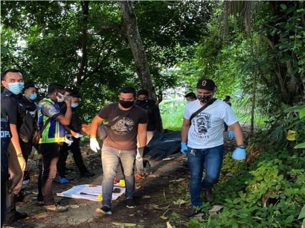 Anggota polis mengangkat mayat mangsa untuk dibawa ke hospital.