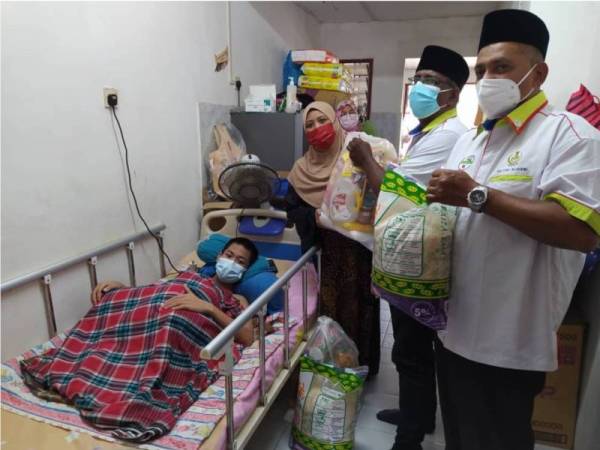 Mohamed Arib (dua dari kanan) menyampaikan sumbangan kepada keluarga Muhammad Akmal di No 64, Haluan Tasek Timur 14, Anjung Bercham Megah, pada Ahad.