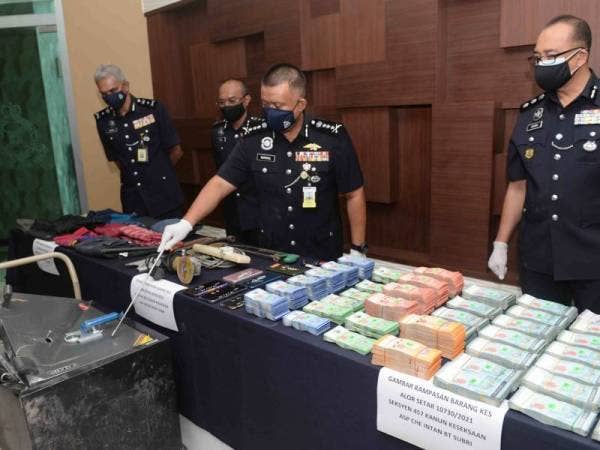 Kamarul Zaman (tengah) menunjukkan peti besi yang dipecahkan pada sidang media selepas berjaya menumpaskan kes pecah pejabat di Ibu Pejabat Polis Kontijen Kedah di Jalan Stadium Sabtu lepas.   - Foto fail Bernama