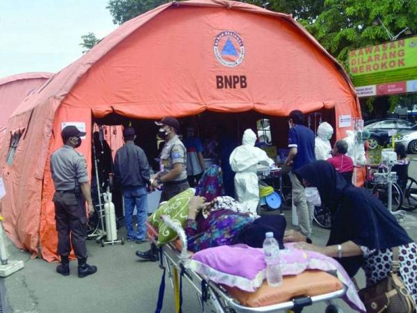 Khemah-khemah kecemasan didirikan untuk merawat para pesakit yang diuji positif dengan Covid-19 di luar Hospital Bekasi, Jawa Barat pada 25 Jun lalu. - Foto AFP