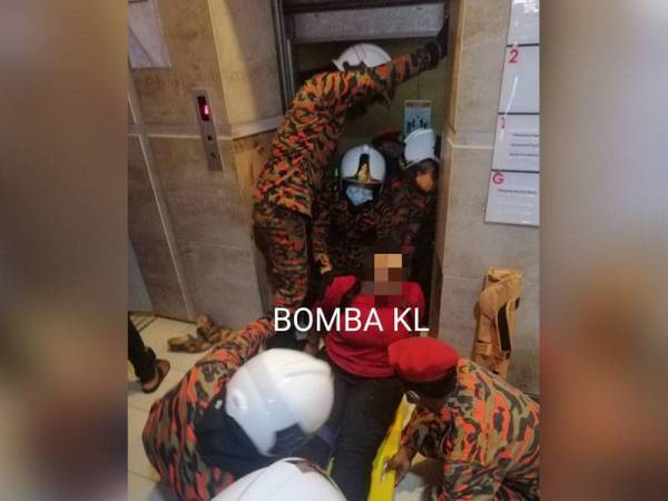 Anggota bomba mengeluarkan mangsa yang terperangkap di dalam lif.