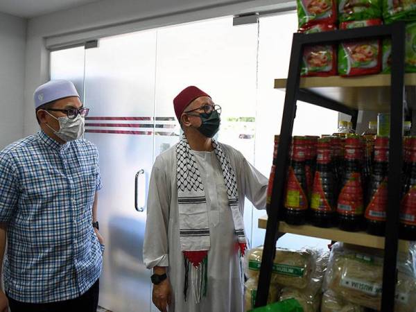 Dr Zulkifli (kanan) melihat 'food bank' di Pusat Khidmat Adun Tepoh untuk mereka yang memerlukan selepas penyerahan pek makanan program Yadim Peduli Musaadah Covid-19 hari ini. -
Foto Bernama