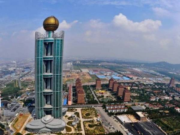 Sebuah hotel lima bintang (kiri) setinggi 328 meter yang bernilai RM1.9 bilion dibina di kampung Huaxi, wilayah Jiangsu. - Foto AFP