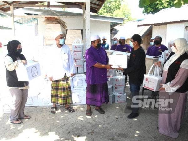 Nezalani (dua dari kanan) menyerahkan set kelengkapan jenazah kepada Pondok Maheliah diwakili Mohd Fadhli Mamat. - FOTO SINAR HARIAN