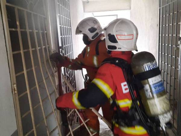 Pihak bomba ketika cuba masuk ke unit rumah tersebut.