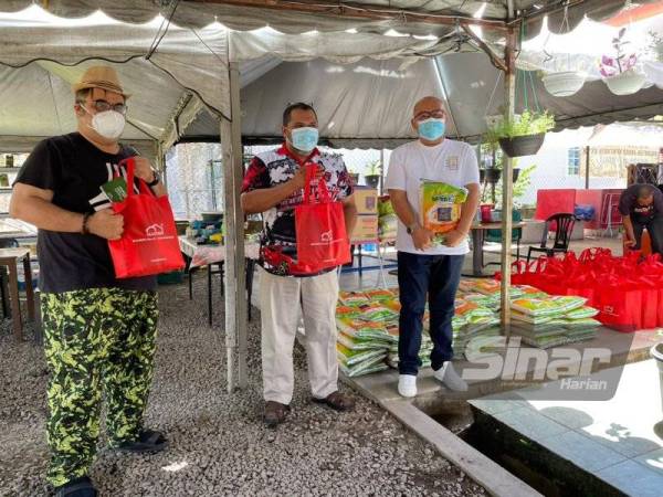 Datuk Tengku Ibrahim Farihaddin Tengku Feissal (kiri) menyampaikan sumbangan bakul makanan kepada Rumah Asnaf Kota Bharu di sini.