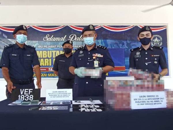 Abdullah (tengah) menunjukkan rokok seludup bernilai RM1.13 juta yang berjaya dirampas di SJR Laloh, Kuala Krai pada Khamis.