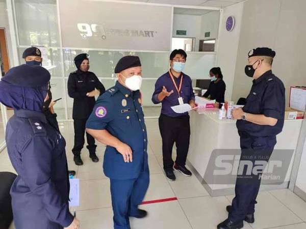 Ketua Polis Daerah Rembau, Hazri (kanan) semasa membuat pemeriksaan di sebuah syarikat di Rembau.