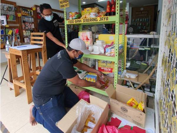 Muhamed Iwaz (kanan) dan Muhammad Shamin menyusun barangan keperluan di 'food bank' yang diusahakan bagi membantu golongan terjejas akibat PKP.