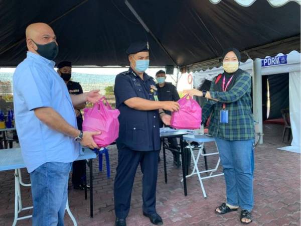 Setiausaha Agung KEMUDI, Siti Fatihah Awang (kanan) menyampaikan sumbangan tersebut kepada Abdullah (tengah) di SJR Jalan Hamzah.