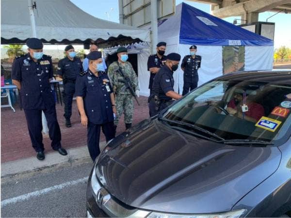 Abdullah (dua, kiri) meluangkan masa meninjau kawalan pergerakan di SJR di Jalan Hamzah, pada Ahad.