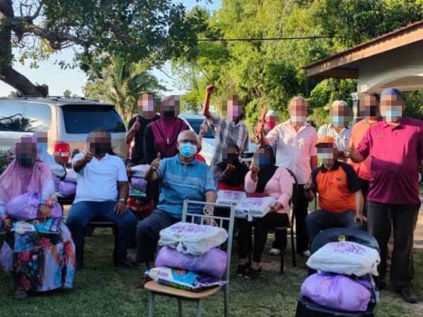 Mahfuz (tengah) bergambar bersama sebahagian penerima bantuan seusai program.
