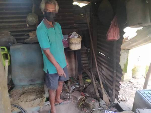 Rashid menunjukkan dapur di luar pondok yang digunakan untuk memasak makanan dan air hujan yang ditadah.