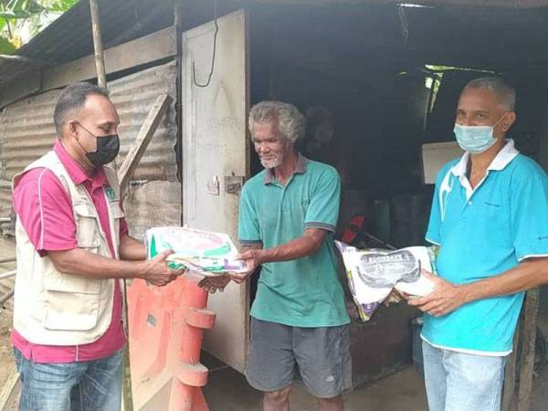 Santharasekaran (kiri) menyampaikan sumbangan beras kepada Rashid.