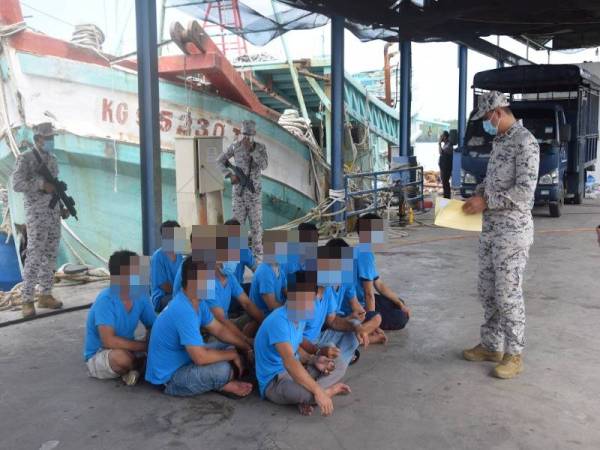 Rashidilhadi (kanan) melakukan pemeriksaan ke atas kesemua nelayan Vietnam yang ditahan di Jeti Zon Maritim Kemaman, pada Selasa