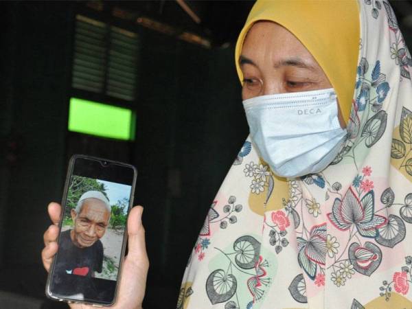 Raneza menunjukkan gambar bapanya, Yaacob yang dilaporkan tidak pulang selepas keluar bersendirian kira-kira 8.30 pagi Ahad. - FOTO: Bernama