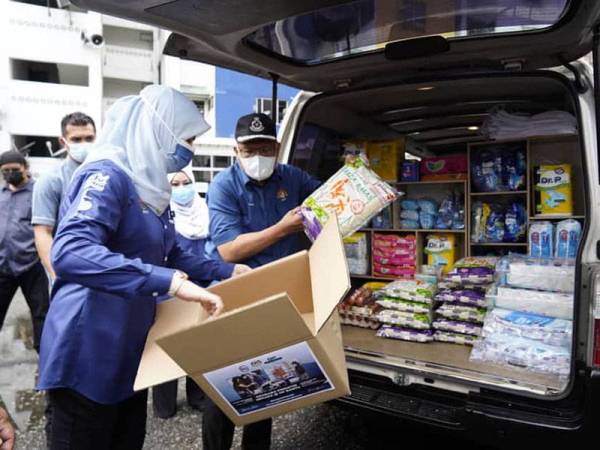 Datuk Seri Rina Mohd Harun (kiri) dan Datuk Seri Hamzah Zainudin mengagihkan bakul makanan kepada lebih 200 ketua isi rumah PPR di Jelatek pada Selasa. Foto Facebook KPWKM