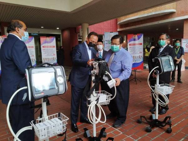 Hasni ( tengah) menyerahkan ventilator kepada Jabatan Kesihatan Negeri Johor di Hospital Sultanah Aminah di sini pada Rabu.