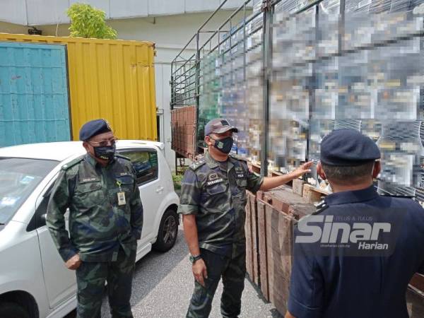 Muhammad (tengah) menunjukkan arak yang dirampas pada sidang akhbar di Ibu Pejabat Polis Daerah Shah Alam pada Khamis.