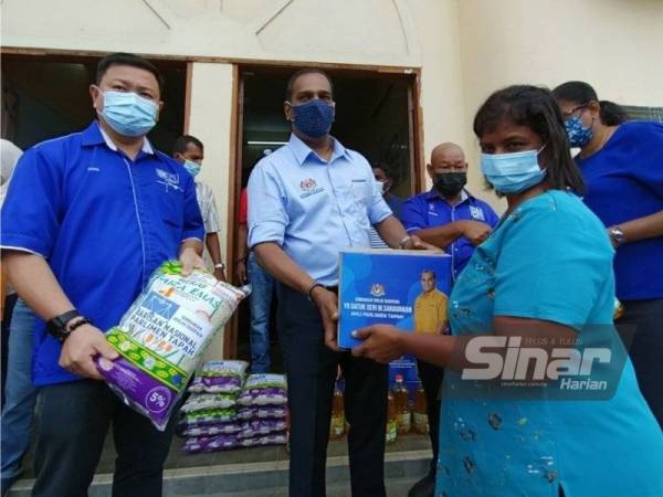 Saravanan menyampaikan bantuan kotak makanan kepada M Tamil Harase, 52, dari
Jalan Besar Tapah sempena program agihan bakul makanan bagi kawasan Parlimen Tapah di Dewan Gandhi pada Khamis.