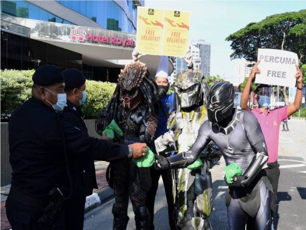 'Adiwira Pulau Pinang' sibuk mengedarkan bungkusan sarapan percuma kepada anggota polis di Jalan Larut, pada Khamis. - Foto Bernama 
