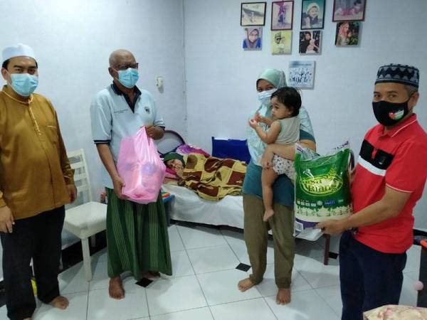 Zainal (dua dari kiri) menerima kehadiran Ahmad Fadzli (kiri) di rumahnya di Taman Sejati, Sungai Petani pada Ahad.