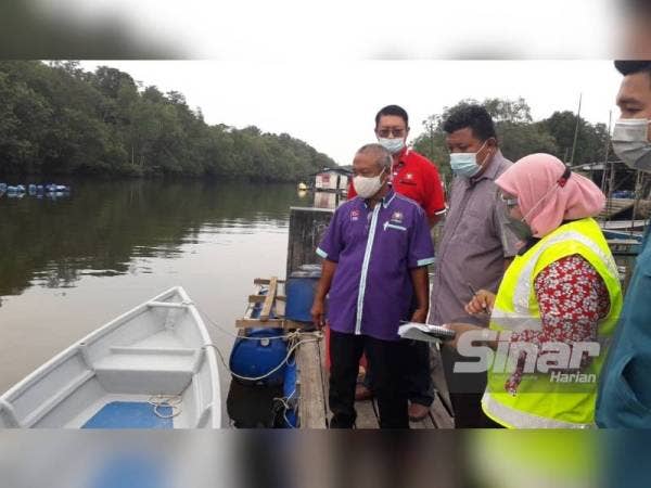 Othman (kiri) dan kakitangan JAS meninjau keadaan air kotor dan berbau akibat pencemaran di Sungai Kopok, Kampung Perigi Acheh, Pasir Gudang, pada Khamis.