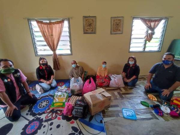 Nordiani (dua dari kanan) menyampaikan sumbangan barangan keperluan asas kepada Noryati dan Muhammad Hisham di Kampung Hutan Gelam.