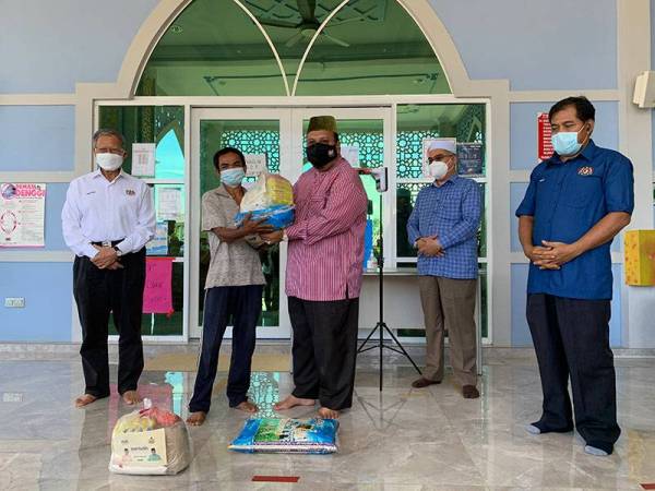 Abdullah (tengah) turut menyampaikan bantuan kepada penduduk di kawasan berkenaan.