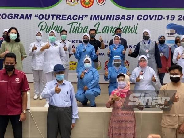 Dr Mahathir (dua dari kiri) bergambar bersama petugas kesihatan di Pusat Pemberian Vaksin (PPV), Dewan KEDA Pulau Tuba, pada Sabtu.