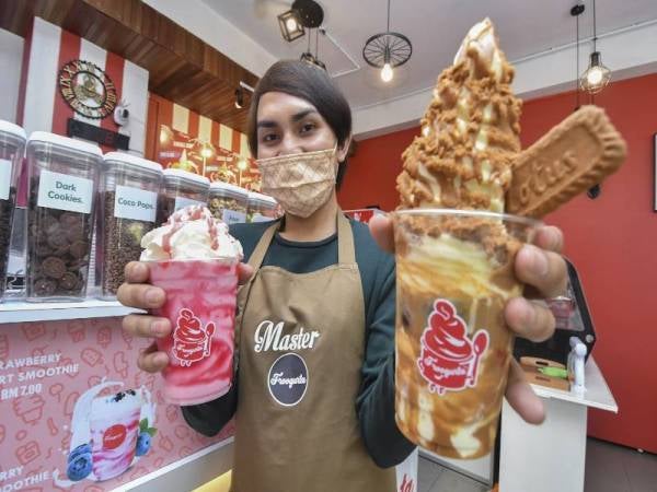 Mohamad Hafizuddin menunjukkan yogurt beku dihasilkan menggunakan resipinya sendiri. - Foto Bernama