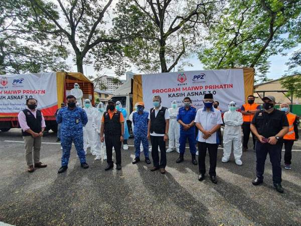 Petugas dan tetamu kehormat yang hadir merakamkan gambar bersama selepas menyerahkan sumbangan kepada penduduk memerlukan di dua lokasi PKPD di sini.