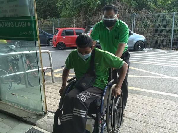 Mas Imran membantu menolak kerusi roda Muhammad Haikal Rezky.