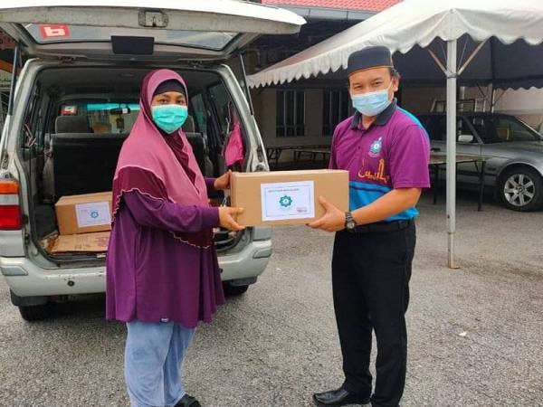 Wakil MAIS (kanan) menyerahkan makanan asas yang diperuntukkan menerusi kutipan fidyah kepada wakil pihak KAFAI di sekitar daerah Petaling pada Selasa.