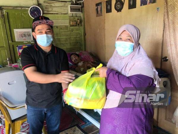 Mohamad Afandi (kiri) menyampaikan sumbangan kepada Rosliah.