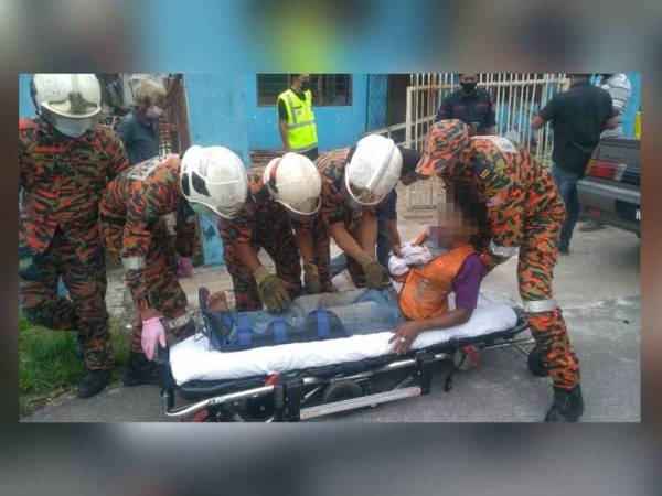 Anggota bomba membantu mengangkat mangsa untuk dibawa ke HRPB. - Foto ihsan Bomba Perak